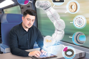 Un progettista lavora durante un viaggio in treno e imposta i movimenti di un braccio robotico